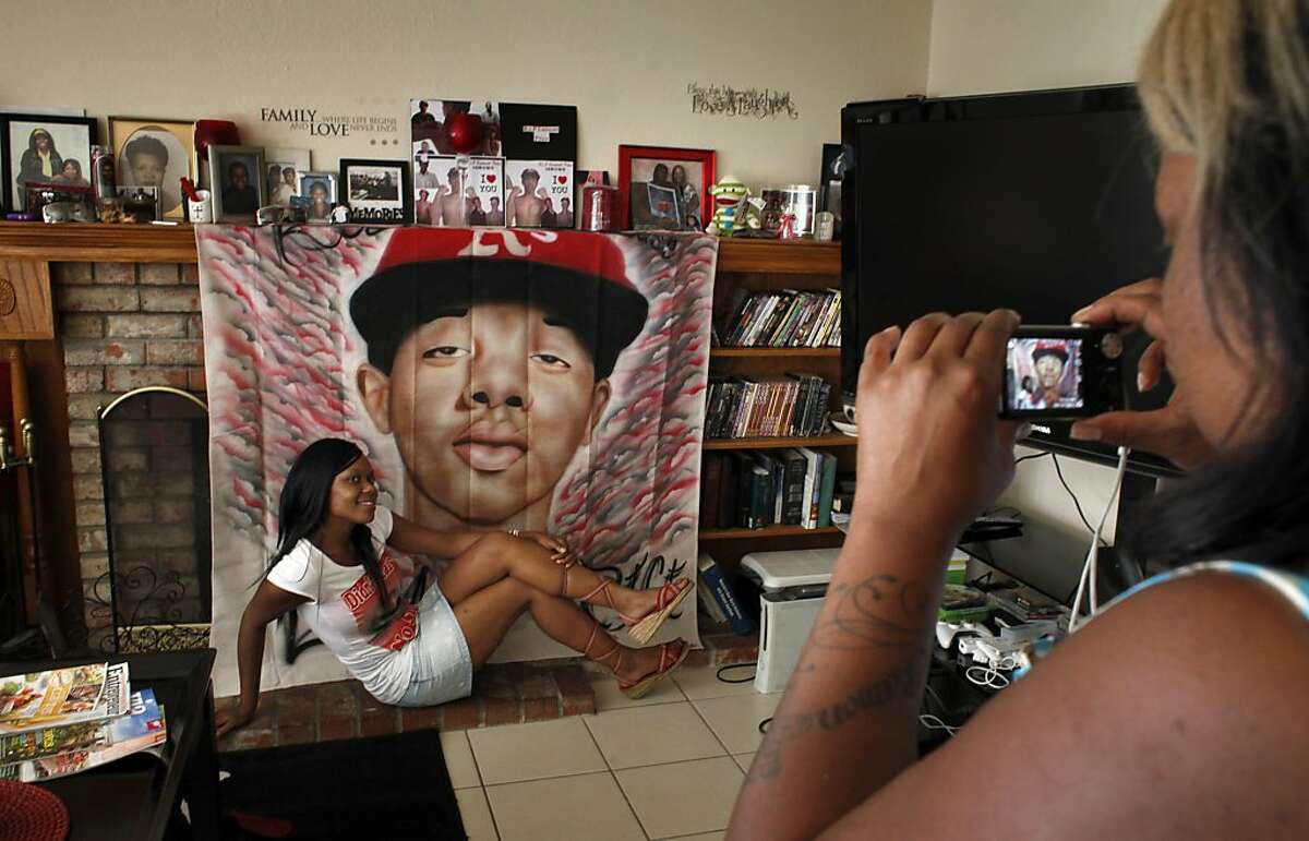 Karlisha Ely, left, poses as Nicole Hodge takes a picture of her with the banner of Lamont Price to commemorate his birthday, Wednesday July 4, 2012, in Antioch, Calif. Photo: Lacy Atkins, The Chronicle