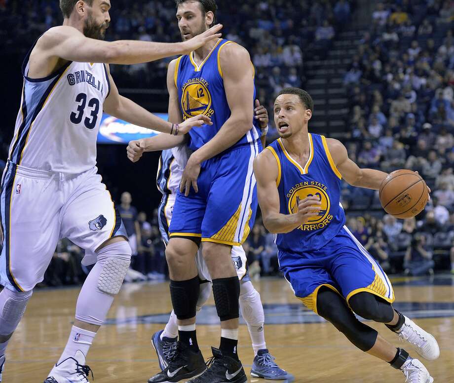Golden State Warriors guard Stephen Curry, right, gets assistance from Warriors center Andrew Bogut (12) as he drives against Memphis Grizzlies center Marc Gasol (33) and guard Mike Conley in the first half of an NBA basketball game Friday, March 27, 2015, in Memphis, Tenn. (AP Photo/Brandon Dill) Photo: Brandon Dill, Associated Press