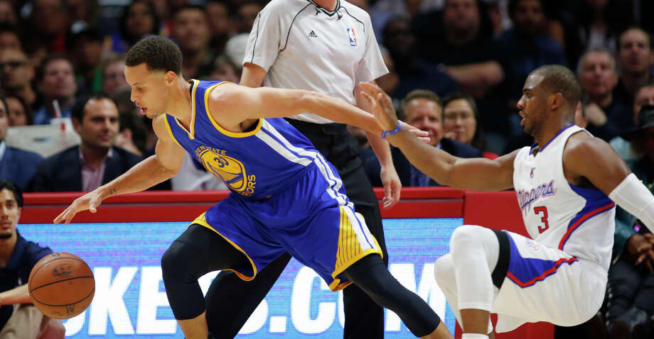 Golden State Warriors' Stephen Curry, left, grabs the ball after dribbling around his back while Los Angeles Clippers Chris Paul, right, falls to the court during the first half of an NBA basketball game, Tuesday, March 31, 2015, in Los Angeles. (AP Photo/Danny Moloshok) Photo: Danny Moloshok, Associated Press